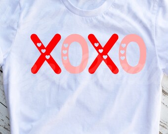 May include: White t-shirt with a red and pink "XOXO" graphic with small white hearts.