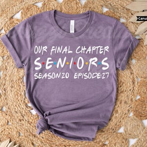May include: A purple t-shirt with the text "OUR FINAL CHAPTER SENIORS SEASON:20 EPISODE:27" in white, with the word "SENIORS" in the style of the TV show "Friends". The shirt is knotted at the bottom.