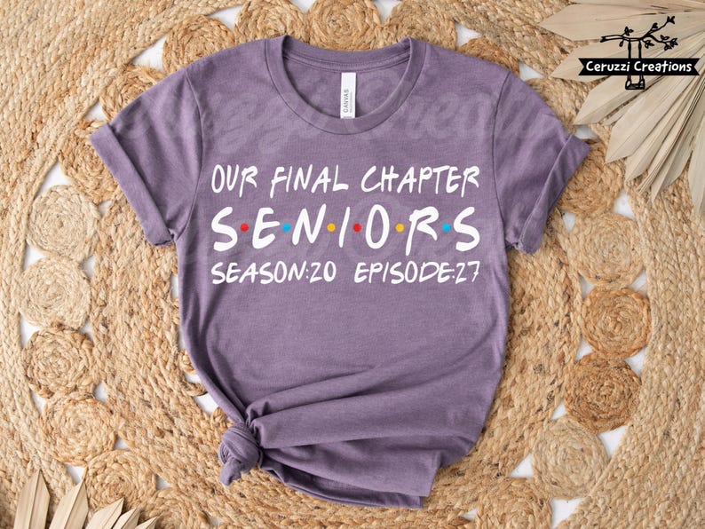 May include: A purple t-shirt with the text "OUR FINAL CHAPTER SENIORS SEASON:20 EPISODE:27" in white, with the word "SENIORS" in the style of the TV show "Friends". The shirt is knotted at the bottom.