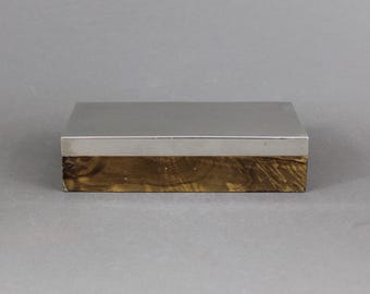 May include: A rectangular wooden box with a silver top. The wood has a dark brown color with a marbled pattern.