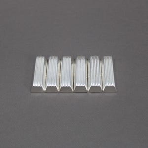 May include: Six silver rectangular bars with a ridged texture, set against a grey backdrop. Each bar has a trapezoidal base. The bars are evenly spaced and arranged horizontally.