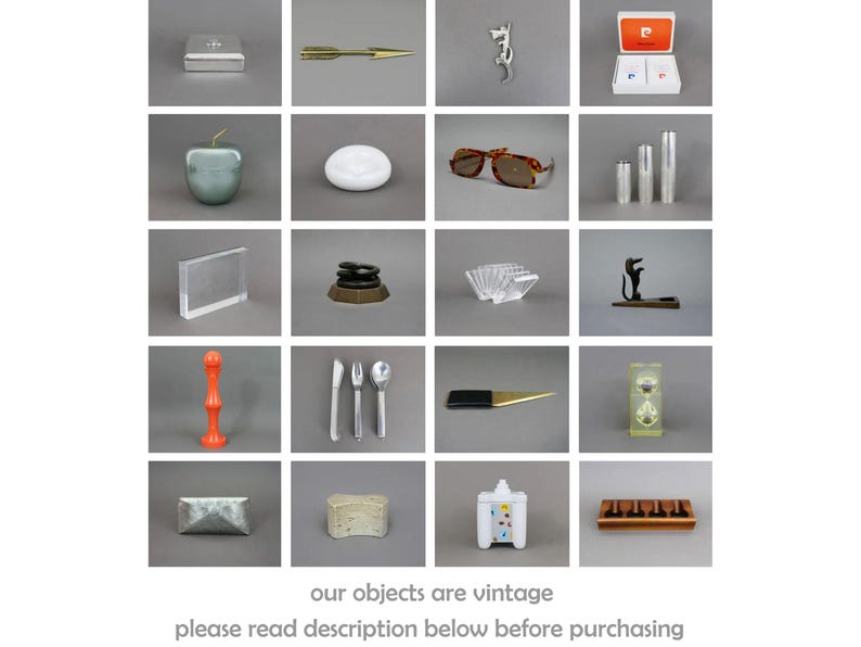 May include: A collection of vintage items arranged in a grid. The items include a silver box, a gold arrow, a silver dragon, a red and white box, a green apple, a white dish, a pair of brown sunglasses, two silver containers, a clear acrylic frame, a stack of black and brown discs, a clear acrylic napkin holder, a black metal dog figurine, a red plastic object, a set of silver cutlery, a black and silver letter opener, a clear glass hourglass, a silver box, a white sponge, a white ceramic house, and a wooden box with four compartments.