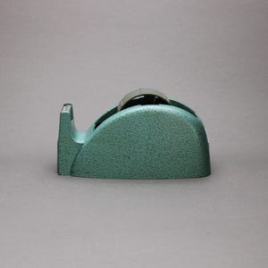 May include: A set of three ceramic mugs with a speckled, matte finish. The mugs are in shades of cream, light gray, and dark gray. Each mug has a simple, minimalist design, perfect for coffee or tea.