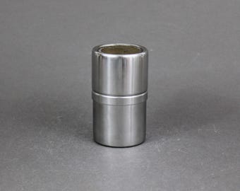 Peut inclure: Un récipient en métal argenté de forme cylindrique lisse. Le récipient a un bord légèrement surélevé autour du haut.