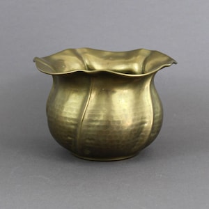 May include: A gold-toned metal planter with a scalloped rim and a hammered finish.