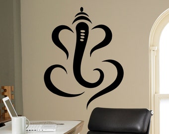 May include: Black and white wall decal of the Hindu deity Ganesha. The decal is in a stylized, abstract design. The decal is on a beige wall in a home office setting.