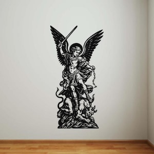 May include: Black and white wall art showing a winged figure with a sword and chain, standing over a defeated horned creature. The artwork is a silhouette, with detailed wings and figures. The art is mounted on a white wall above a wooden floor.