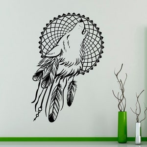 May include: Black and white silhouette of a wolf howling at the moon, inside a dreamcatcher with feathers. The design is perfect for a wall decal.