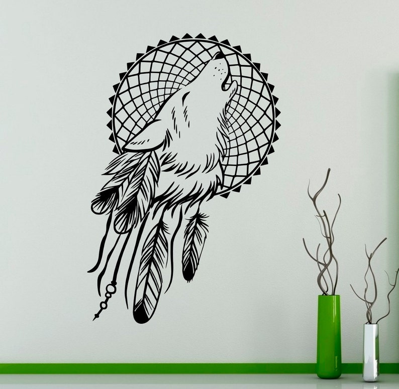 May include: Black and white silhouette of a wolf howling at the moon, inside a dreamcatcher with feathers. The design is perfect for a wall decal.