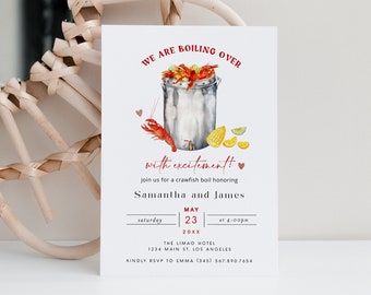 Puede incluir: Una tarjeta de invitación blanca con texto rojo que dice "We are boiling over with excitement!" y presenta una ilustración de acuarela de una olla de cangrejos de río. La invitación es para un hervido de cangrejos de río en honor a Samantha y James el sábado 23 de mayo a las 4:00 pm en el Hotel The Limao, 1234 Main St., Los Ángeles. La invitación solicita una RSVP a Emma al (345) 567.890.7654.