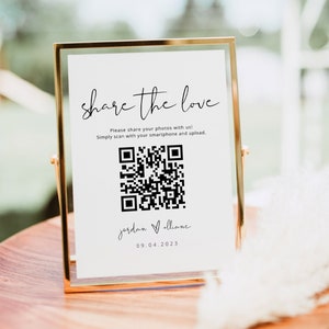 Könnte beinhalten: Ein weißes Schild in einem goldenen Rahmen mit dem Text "share the love" und einem QR-Code. Der Text unter dem QR-Code lautet "jordan & alliane 09.04.2023".