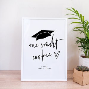 May include: White frame with a black graduation cap and the text "one smart cookie" with a heart. Below the text is "Please take a treat".