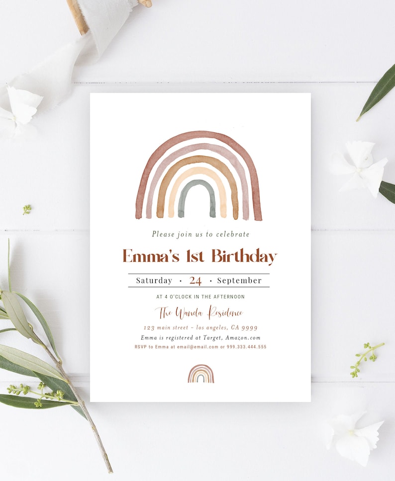 May include: A white invitation card with a watercolor rainbow design in shades of brown, tan, and gray. The text reads "Emma's 1st Birthday" with event details. The card is decorated with floral accents.
