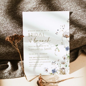 May include: A white invitation card with a floral design and gold lettering. The text reads "Please join us for a Bridal Brunch honoring the bride-to-be Samantha Smith 10.04.22 | 10:00am The Smith Farmhouse 123 Avenue 1234 Dallas, TX RSVP to Emmy at 000.000.000 registered at target and amazon.com"