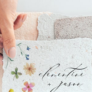 Peut inclure: Papier fait &agrave; la main avec des accents floraux et les noms "Clementine + Jason" en &eacute;criture &eacute;l&eacute;gante. Le papier a un bord dentel&eacute; et est orn&eacute; de fleurs et de verdure press&eacute;es, parfait pour les faire-part de mariage ou la papeterie.