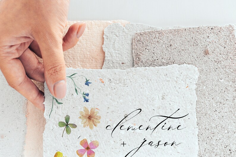 Peut inclure: Papier fait &agrave; la main avec des accents floraux et les noms "Clementine + Jason" en &eacute;criture &eacute;l&eacute;gante. Le papier a un bord dentel&eacute; et est orn&eacute; de fleurs et de verdure press&eacute;es, parfait pour les faire-part de mariage ou la papeterie.