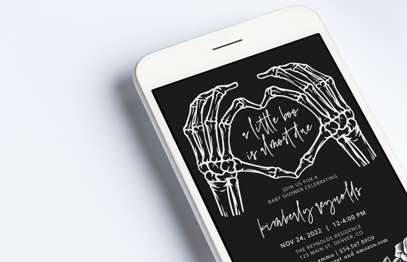 May include: Black and white baby shower invitation with a skeleton hand forming a heart shape. The text reads "a little boo is almost here" and includes the date, time, and location of the event.
