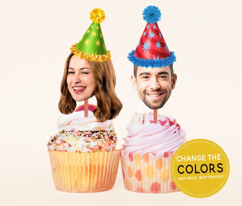 May include: Two cupcakes with colourful frosting and sprinkles. Each cupcake has a person's face on a stick, wearing a party hat. The text on the yellow sign says "Change the Colours, Best Price, Best Service."