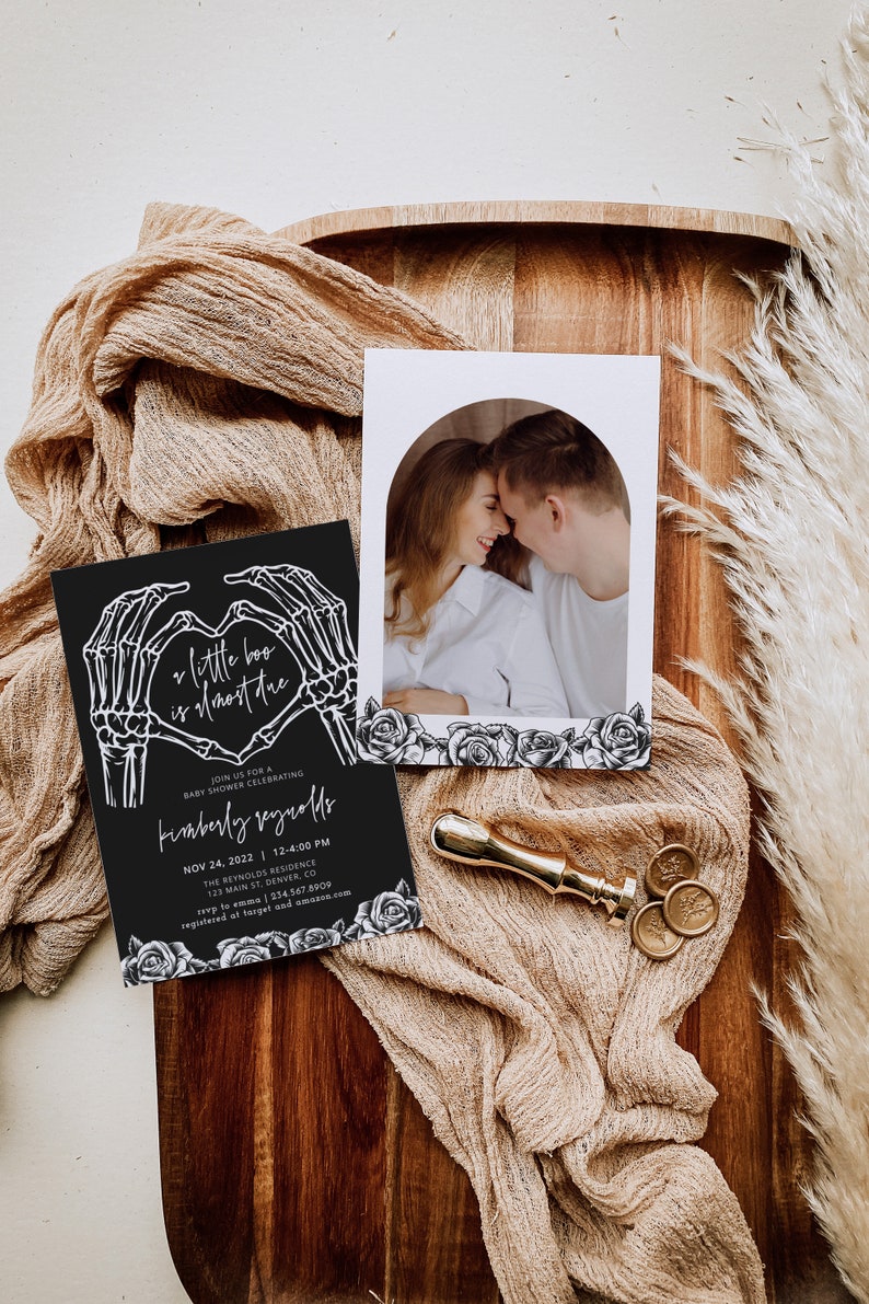 May include: A black and white baby shower invitation with a skeleton hand heart design. The text reads "a little boo is almost here" and "Kimberly Reynolds". The invitation includes the date, time, and location of the event.