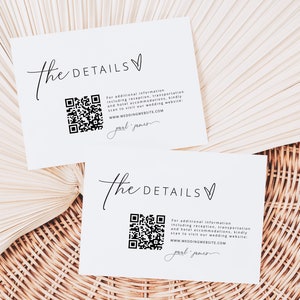 Peut inclure: Deux cartes blanches avec du texte noir et un code QR. Le texte sur les cartes indique "The Details" et inclut un lien vers un site Web de mariage. Les cartes sont sur une surface en osier tressé.