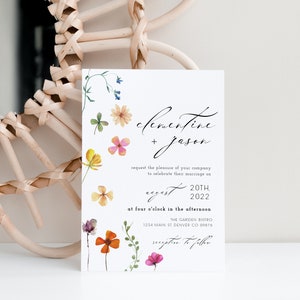 Peut inclure: Une invitation de mariage blanche avec des accents floraux &agrave; l'aquarelle et une &eacute;criture &eacute;l&eacute;gante. L'invitation comprend les noms "Clementine + Jason", la date, l'heure et les d&eacute;tails du lieu. Un cadre de miroir circulaire tiss&eacute; est en arri&egrave;re-plan.