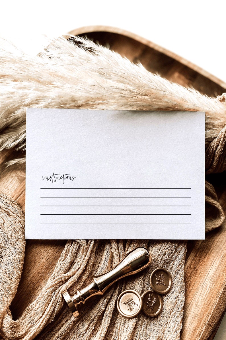 Puede incluir: Una tarjeta blanca con la palabra "instrucciones" escrita en ella, con l&iacute;neas para escribir. La tarjeta est&aacute; sobre una superficie de madera con un sello de cera dorado y una tela decorativa.