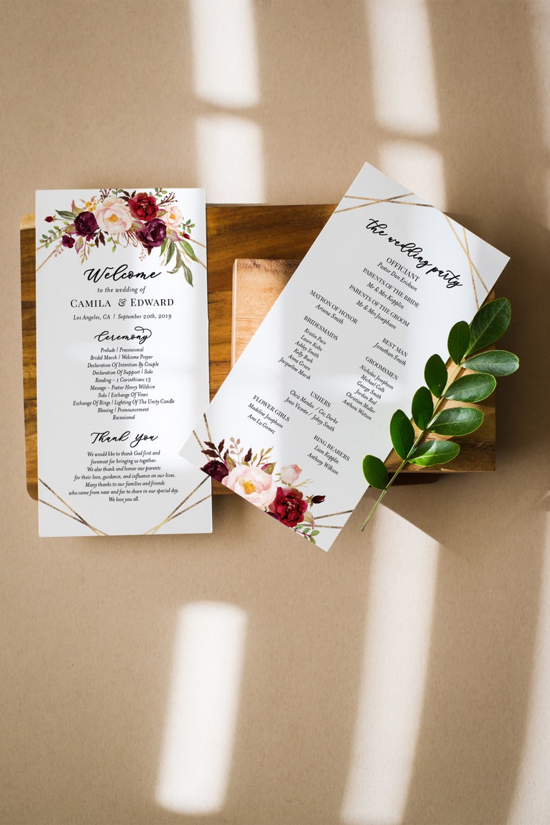 May include: Wedding ceremony program with a floral design featuring burgundy and pink flowers. The program includes the officiant, parents of the bride and groom, matron of honor, bridesmaids, best man, groomsmen, ushers, flower girls, and ring bearers.