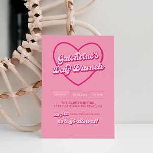 May include: Pink invitation card with a heart-shaped graphic that says "Galentine's Day Brunch". The card includes details for the event, including the date, time, location, and RSVP information. The text "no boys allowed!" is written in a playful font.
