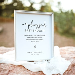 May include: A white sign with black text that reads "unplugged baby shower". The sign also includes the text "Please respect this beautiful day by not posting photos or videos to social media. Thank you!" and "Adella's Baby Shower 09.10.20XX".