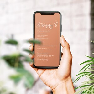 May include: A smartphone displaying a peach-coloured itinerary for a family reunion. The itinerary includes details for Friday evening, Saturday morning, and Sunday morning. The text on the screen reads "itinerary" with a heart symbol and "Family Reunion".
