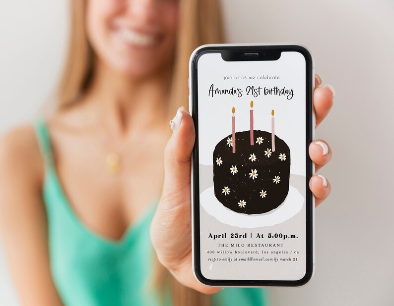 Peut inclure: L'&eacute;cran d'un smartphone affichant une invitation d'anniversaire pour le 21e anniversaire d'Amanda. L'invitation repr&eacute;sente un g&acirc;teau noir avec des fleurs blanches et des bougies roses. Le texte indique "join us as we celebrate Amanda's 21st birthday", "April 23rd at 5:00p.m.", "THE MILO RESTAURANT", "400 willow boulevard, los angeles, ca", "RSVP to emily at email@email.com by march 21".