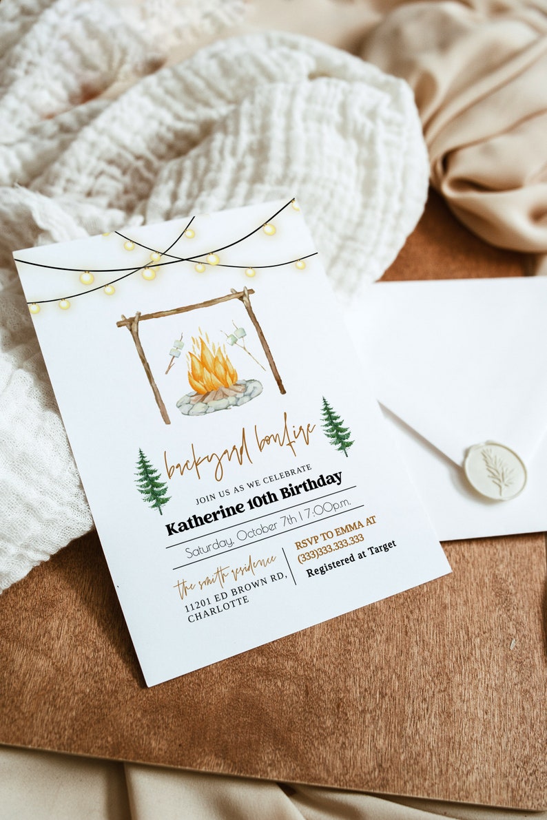 May include: A white invitation card with a watercolor illustration of a campfire with marshmallows roasting over the flames. The text on the card reads "backyard bonfire" and "Katherine 10th Birthday".