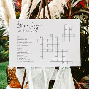 May include: A white crossword puzzle with the title "Lilly + James SIP & SOLVE" printed at the top. The crossword puzzle has 14 clues, with 7 clues listed under "DOWN" and 7 clues listed under "ACROSS".