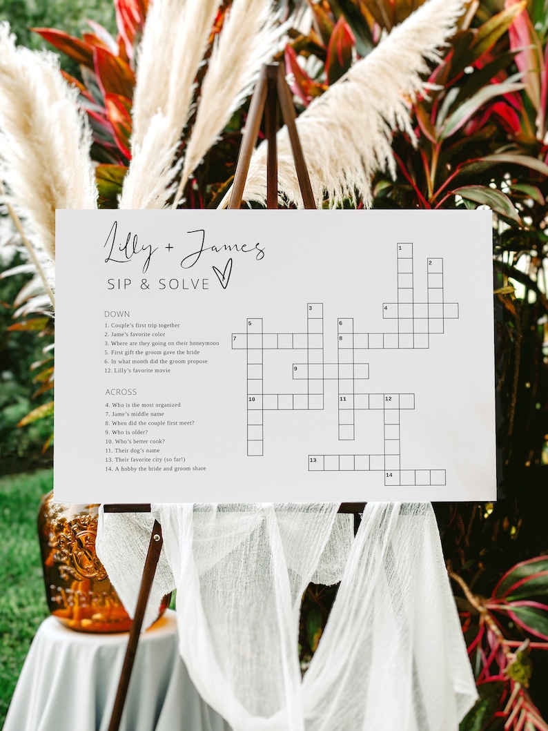 May include: A white crossword puzzle with the title "Lilly + James SIP & SOLVE" printed at the top. The crossword puzzle has 14 clues, with 7 clues listed under "DOWN" and 7 clues listed under "ACROSS".