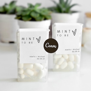 Könnte beinhalten: Zwei durchsichtige, rechteckige Kunststoffbehälter gefüllt mit weißen Minzbonbons. Jeder Behälter hat ein weißes Papieretikett mit dem Text MINT TO BE, einem handgezeichneten Herzsymbol sowie den Namen Adella und Michael und dem Datum 02.03.21.