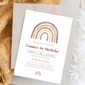 May include: A birthday invitation featuring a watercolor rainbow design in shades of brown, beige, and gray. The text reads "Emma's 1st Birthday" with event details. The invitation is placed on a neutral-toned envelope.