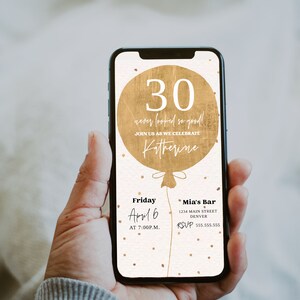 May include: A digital invitation on a smartphone screen with a gold balloon graphic that says "30 never looked so good!" and "Join us as we celebrate Katherine". The invitation details are for a party on Friday, April 6 at 7:00 PM at Mia's Bar, 1234 Main Street, Denver. The RSVP number is 555.555.555.