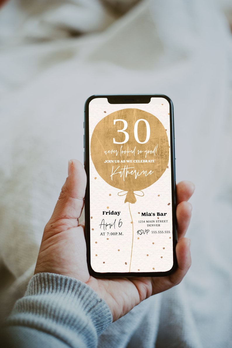 May include: A digital invitation on a smartphone screen with a gold balloon graphic that says "30 never looked so good!" and "Join us as we celebrate Katherine". The invitation details are for a party on Friday, April 6 at 7:00 PM at Mia's Bar, 1234 Main Street, Denver. The RSVP number is 555.555.555.