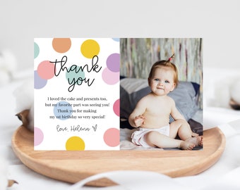 May include: A colorful thank you card with a photo of a baby girl. The card has a polka dot pattern in pink, blue, yellow, and green. The text on the card reads "thank you" and "I loved the cake and presents too, but my favorite part was seeing you! Thank you for making my 1st birthday so very special! love. Helena."