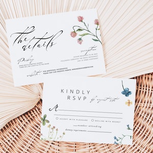 Peut inclure: Deux cartons d'invitation de mariage blancs avec des accents floraux et une calligraphie &eacute;l&eacute;gante. L'un des cartons indique "the details" et l'autre "Kindly RSVP". Les cartons sont d&eacute;cor&eacute;s de fleurs &agrave; l'aquarelle roses, bleues et jaunes.