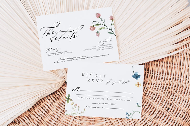 Peut inclure: Deux cartons d'invitation de mariage blancs avec des accents floraux et une calligraphie &eacute;l&eacute;gante. L'un des cartons indique "the details" et l'autre "Kindly RSVP". Les cartons sont d&eacute;cor&eacute;s de fleurs &agrave; l'aquarelle roses, bleues et jaunes.