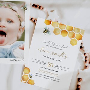 May include: A yellow and white bee-themed first birthday party invitation with a watercolor honeycomb pattern. The invitation reads "Sweet as can bee! Join us in celebrating Alana Smith's First Bee-Day! Saturday, April 20, 2021 at 4:00 in the afternoon. The Henderson Residence, 123 Main Street, Dallas, TX 999. RSVP to Aline at 333-444-555 by April 1st. Registered at Target and Amazon.com."