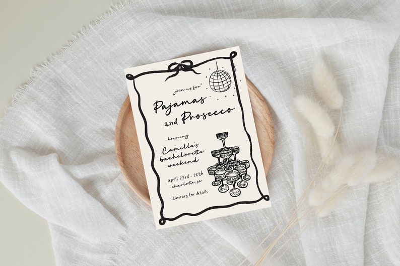 May include: A black and white illustration of a disco ball and champagne glasses on a cream-colored card with the text "Joining for Pajamas and Prosecco honoring Camille's bachelorette weekend April 23rd-26th Charlotte, NC Itinerary for details"