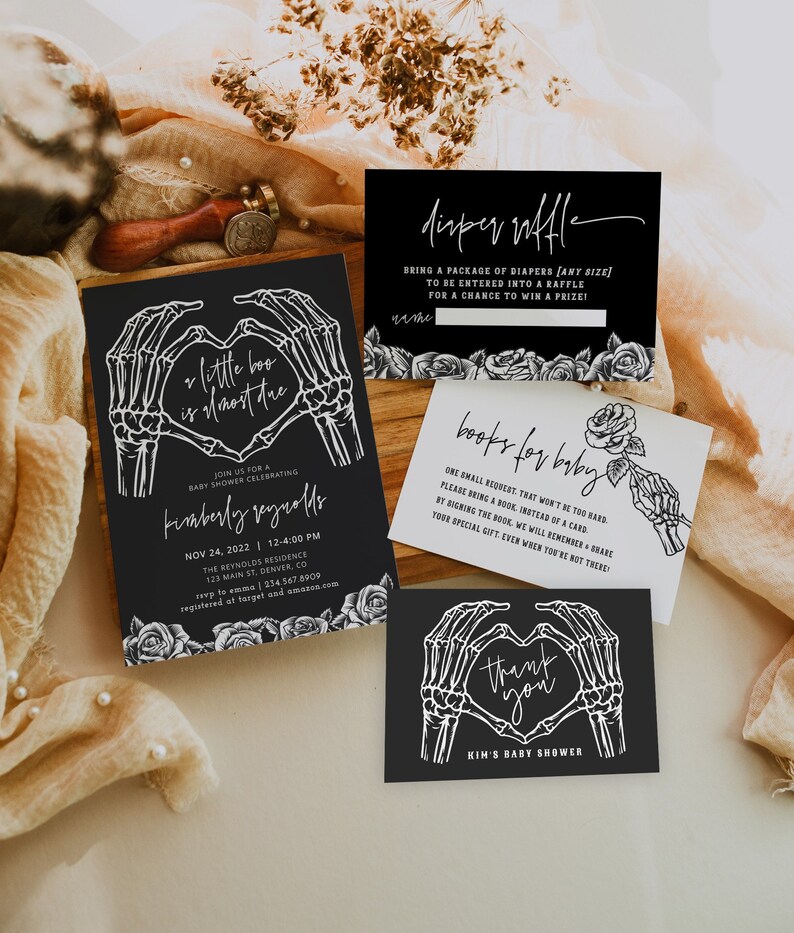 May include: Black and white invitation for a baby shower with a skeleton hand heart design. The invitation reads "Little Boo is almost due" and includes the date, time, and location of the event.  There are also cards for a diaper raffle and a book request for the baby.