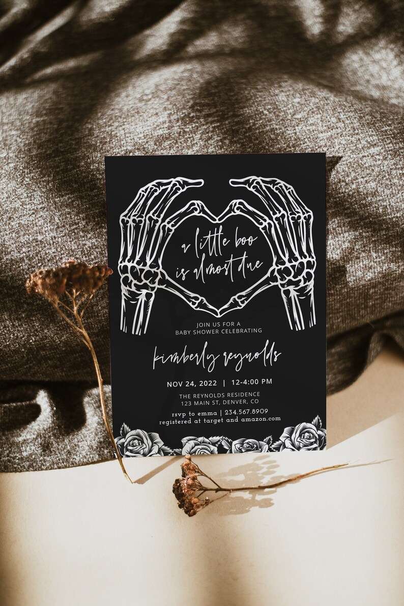 May include: Black and white baby shower invitation with a skeleton hand heart design. The text reads "a little boo is almost due" and includes the date, time, location, and RSVP information.