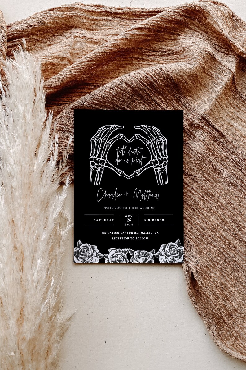 May include: Black wedding invitation with white skeleton hands forming a heart with the text "till death do us part" and the couple's names "Charlie + Matthew". The invitation includes the date, time, and location of the wedding.