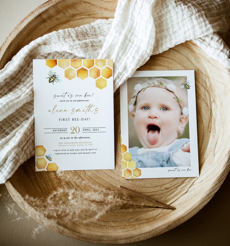 May include: A yellow and gold honeycomb pattern with a bee on a white background. The text "sweet as can bee!" is written in gold script. The text "Join us in celebrating Alena Smith's First Bee-Day!" is written in black. The text "Saturday, April 20, 2021, at 4:00 in the afternoon, The Henderson Residence, 123 Main Street, Dallas, TX 75222, RSVP to [phone number] by April [date], registered at Target and Amazon.com" is written in black.