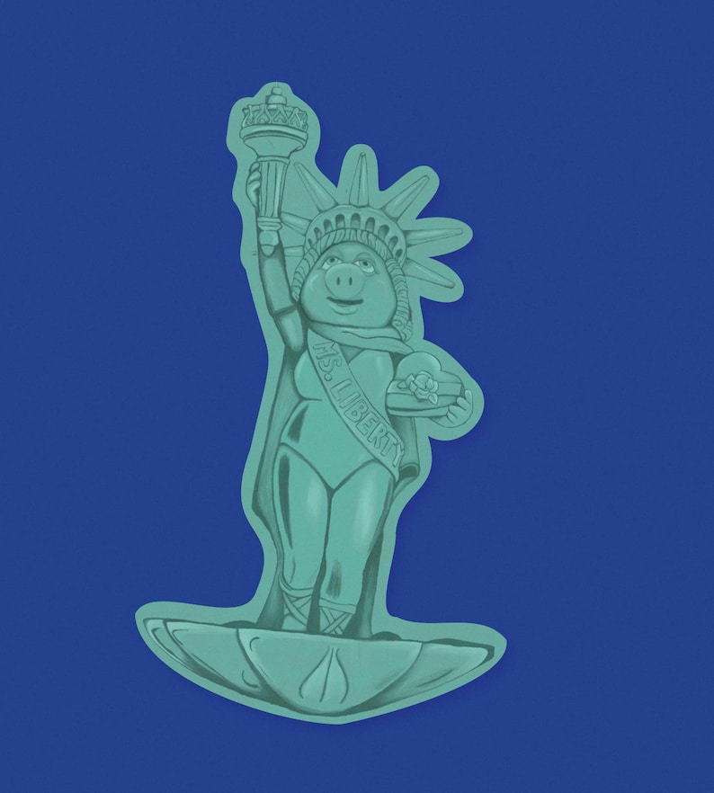 Pu&ograve; includere: Una statua verde di un maiale vestito come la Statua della Libert&agrave;, che tiene una piccola corona nella mano destra e una piccola scatola nella mano sinistra. La statua &egrave; in piedi su una base verde. La statua indossa una corona e una fascia che dice "Ms. Liberty".