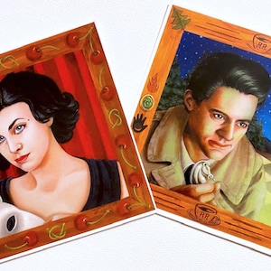 May include: Two framed illustrations, one featuring a woman in a black dress holding a white animal, the other depicting a man in a brown jacket holding a white horse figurine. Both frames are adorned with cherries and have a red background.