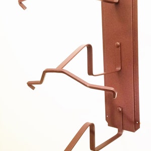 Peut inclure: Un porte-chapeau mural en m&eacute;tal de couleur rouille avec trois crochets. Le porte-chapeau est con&ccedil;u pour tenir des chapeaux, des casquettes ou d'autres couvre-chefs.